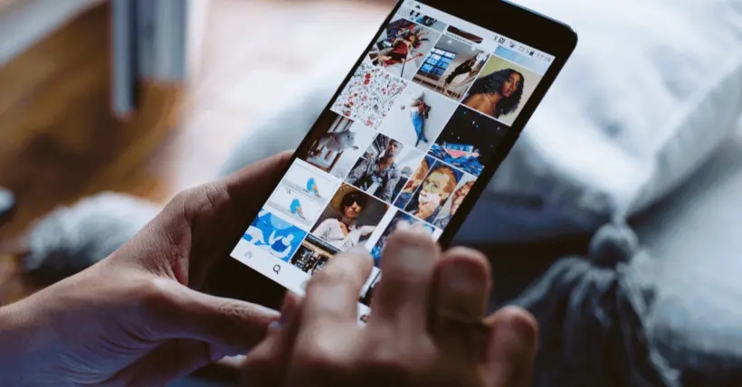 Hands holding a smartphone showing a grid of online images