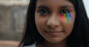 A girl with rainbow makeup under her left eye